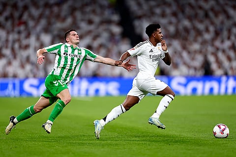 La Liga 2024-25 Real Madrid vs Real Betis: Betis' Romain Perraud, left, challenges Real Madrid's Rodrygo